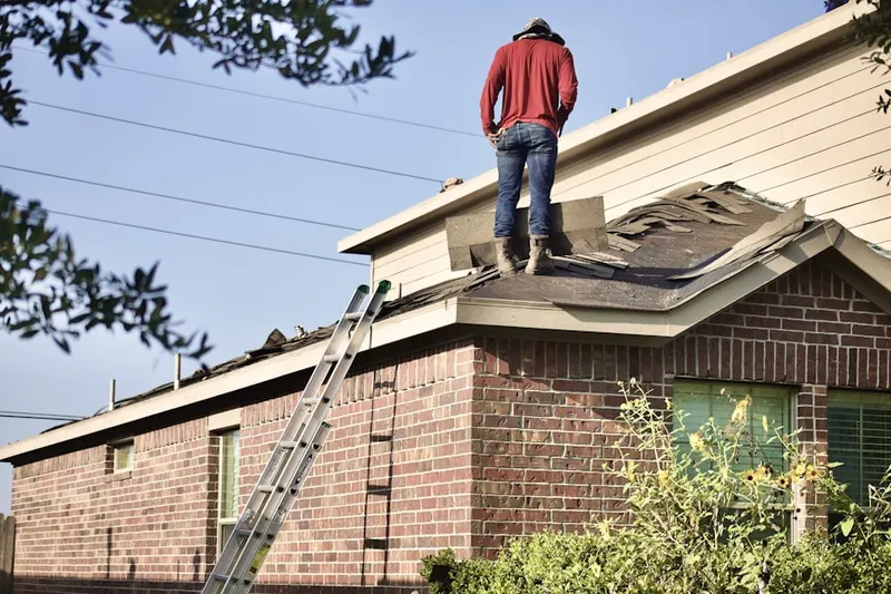 Professional roofer working on a residential roof in Quiogue